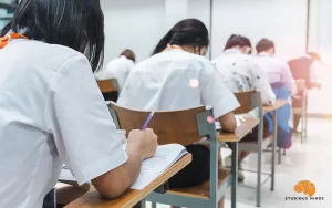 Asian Students Taking An Examination In Classroom